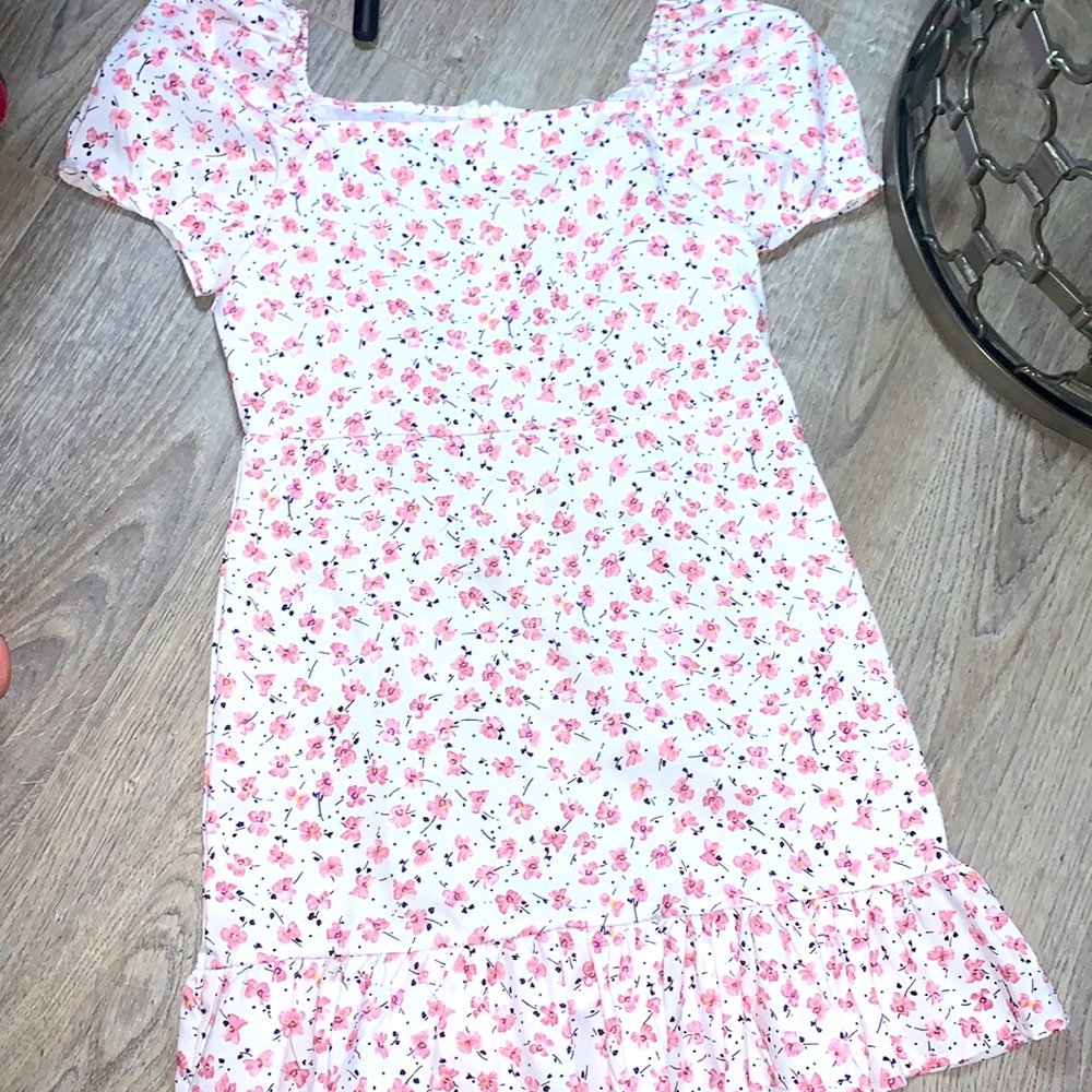 Has zipper on back. The design is pink flowers. And has puffy sleeves.